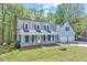 Traditional two-story home with a brick chimney, inviting porch, and lush green lawn at 1433 Andersonwood Dr, Fuquay Varina, NC 27526