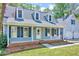 Charming front porch with blue siding, leading to a welcoming front door and two-car garage at 1433 Andersonwood Dr, Fuquay Varina, NC 27526