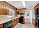 Kitchen featuring wood cabinets, a mosaic backsplash, and modern appliances at 1433 Andersonwood Dr, Fuquay Varina, NC 27526