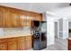 A kitchen area showing dark appliances, tile backsplash, and wood cabinets at 1433 Andersonwood Dr, Fuquay Varina, NC 27526