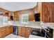 Charming kitchen with wood cabinets and sleek black appliances offering ample counter space at 1433 Andersonwood Dr, Fuquay Varina, NC 27526