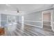 Bright, open living room with modern gray flooring, ceiling fan, and doors to the backyard at 1433 Andersonwood Dr, Fuquay Varina, NC 27526