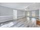 Spacious living room featuring modern gray flooring, ample lighting, and a cozy brick fireplace at 1433 Andersonwood Dr, Fuquay Varina, NC 27526