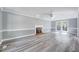 Spacious living room with modern gray flooring, fireplace, and French doors to the patio at 1433 Andersonwood Dr, Fuquay Varina, NC 27526