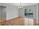 Open dining area with sliding glass doors, elegant chandelier and wood floors at 1517 Laughridge Dr, Cary, NC 27511