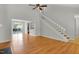 Open-concept living room has wood flooring and stairs that lead to upper level at 1517 Laughridge Dr, Cary, NC 27511