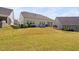 Exterior view of the rear of the home with a beautiful stone fire pit and well-kept lawn at 158 Sea Foam Dr, Raleigh, NC 27610