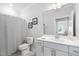 A well-lit bathroom with a striped shower curtain and a white vanity at 158 Sea Foam Dr, Raleigh, NC 27610