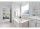 Bright bathroom featuring a soaking tub with tile surround and view to the bedroom at 158 Sea Foam Dr, Raleigh, NC 27610