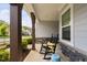 Inviting front porch with a rocking chair, wooden beams, manicured landscaping and stylish decor at 158 Sea Foam Dr, Raleigh, NC 27610