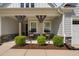 Inviting front porch with rocking chairs, wooden beams, manicured landscaping, and stylish decor at 158 Sea Foam Dr, Raleigh, NC 27610