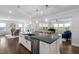 Open-concept kitchen with stainless steel appliances, island, and view of the living area at 158 Sea Foam Dr, Raleigh, NC 27610