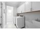 A modern laundry room with white cabinets and a sink at 158 Sea Foam Dr, Raleigh, NC 27610