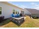 Charming patio with stone seating, grill, blue Adirondack chairs, and backyard views at 158 Sea Foam Dr, Raleigh, NC 27610