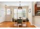 Warm dining area featuring hardwood floors, abundant natural light, and a view into the kitchen, perfect for gatherings at 162 Grey Elm Trl, Durham, NC 27713