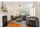 Cozy living room featuring hardwood floors, neutral tones, fireplace, and ample natural light from large windows at 162 Grey Elm Trl, Durham, NC 27713