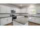 Well-lit kitchen features white cabinets, granite countertops, and stainless steel appliances at 189 Calebs Corner Pl, Spring Lake, NC 28390