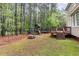 Home's expansive backyard features a wooden deck, playground, lush trees, and green grass at 2 Piney Ridge Ct, Durham, NC 27712