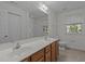 Bathroom featuring double sinks with wood cabinets and a large mirror, with lots of natural light from the window at 2 Piney Ridge Ct, Durham, NC 27712