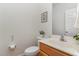 Half bathroom with oak vanity, picture frame, and neutral colors at 2 Piney Ridge Ct, Durham, NC 27712