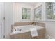 Bright bathroom featuring a large soaking tub with tile surround at 2 Piney Ridge Ct, Durham, NC 27712