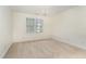 Empty bedroom with neutral carpet, a window and a decorative chandelier at 2 Piney Ridge Ct, Durham, NC 27712