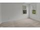Bright bedroom featuring neutral carpet, white walls, and two windows providing natural light at 2 Piney Ridge Ct, Durham, NC 27712