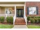 Inviting front porch with brick steps, white railings, and well-maintained landscaping at 2 Piney Ridge Ct, Durham, NC 27712