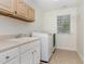 Bright laundry room with sink, counter, storage and new front load washer and dryer at 2 Piney Ridge Ct, Durham, NC 27712