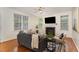 Cozy living room with fireplace, hardwood floors, and multiple windows at 2 Piney Ridge Ct, Durham, NC 27712