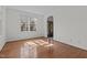 Bright, empty living room featuring hardwood floors and large window for natural light at 2 Piney Ridge Ct, Durham, NC 27712