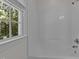 Shower with a white tub and showerhead, a window with natural light and a view of the trees at 2 Piney Ridge Ct, Durham, NC 27712