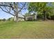 Expansive backyard featuring lush green grass and mature trees, a perfect outdoor retreat for relaxation and recreation at 205 W Moore St, Apex, NC 27502