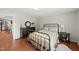A bedroom featuring hardwood floors, a wrought iron bed frame, and a view into an adjacent kitchen at 205 W Moore St, Apex, NC 27502