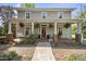 Charming front porch with hanging ferns, brick pillars, and a welcoming swing at 205 W Moore St, Apex, NC 27502