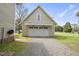Detached garage features carriage doors, a gravel driveway, and well-maintained lawn at 205 W Moore St, Apex, NC 27502