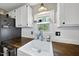 Kitchen sink featuring a window view, butcher block countertops, and white paneled backsplash at 205 W Moore St, Apex, NC 27502