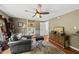 A living room that features a ceiling fan, leather chair, natural light, and hardwood flooring at 205 W Moore St, Apex, NC 27502