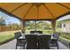 Relaxing outdoor dining area with a gazebo, dining table, and view of the landscaped backyard at 205 W Moore St, Apex, NC 27502