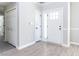 Bright entryway with light gray walls, wood-look floors, a coat closet, and a modern white front door with glass panels at 211 Milky Way Dr, Apex, NC 27502