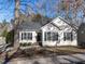 Charming single-story home showcasing a well-maintained lawn and inviting curb appeal with a black door and black shutters at 211 Milky Way Dr, Apex, NC 27502
