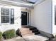 A welcoming front entrance featuring a dark-stained wood porch, black door with glass, and light-colored siding at 211 Milky Way Dr, Apex, NC 27502