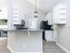 Modern kitchen featuring white cabinets, granite countertops, stainless steel appliances, and an adjoining living space at 211 Milky Way Dr, Apex, NC 27502