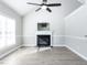 Light-filled living room with a fireplace, vaulted ceiling, wood-look floors, and a modern ceiling fan at 211 Milky Way Dr, Apex, NC 27502