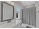 Well-lit bathroom with quartz countertops, modern fixtures, and a gray shower curtain at 2432 Spindle Ct, Raleigh, NC 27603