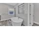Stylish bathroom with a freestanding tub, tiled accent wall, and a glass-enclosed shower at 2432 Spindle Ct, Raleigh, NC 27603