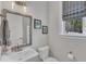 Clean half-bath featuring a mirror, pedestal sink, toilet and window with blinds at 2432 Spindle Ct, Raleigh, NC 27603