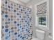 Bright bathroom with a polka dot shower curtain and a patterned window shade at 2432 Spindle Ct, Raleigh, NC 27603