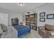 Relaxing bedroom features a bookshelf, dark furniture, and a leather armchair at 2432 Spindle Ct, Raleigh, NC 27603