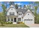 Stunning new construction farmhouse with a two-car garage, white siding, and a beautifully landscaped lawn at 2432 Spindle Ct, Raleigh, NC 27603